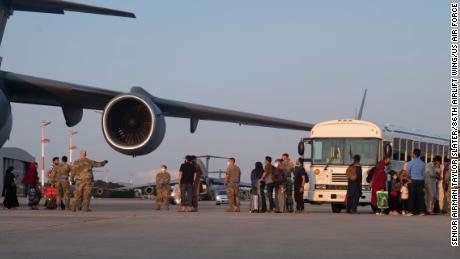Um grupo de evacuados afegãos deixa uma aeronave C-17 Globemaster III na Base Aérea de Ramstein, Alemanha, 20 de agosto de 2021.