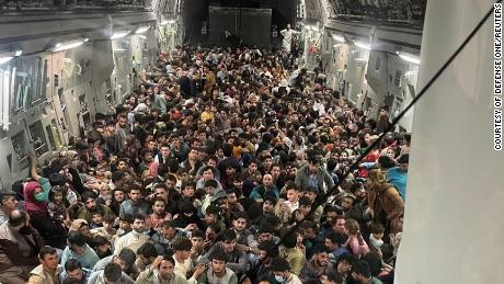 Evacuados se reúnem dentro de um avião de transporte C-17 Globemaster III da Força Aérea dos EUA em um vôo com destino ao Catar de Cabul, Afeganistão, em 15 de agosto de 2021. A Força Aérea disse na sexta-feira que o avião transportava um recorde de 823 pessoas.