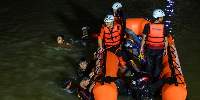 Equipes de resgate procuram vítimas de afogamento em um rio em Ciamis, Java Ocidental, Indonésia, sexta-feira, 15 de outubro de 2021. 