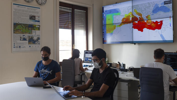As pessoas trabalham em salas de controle com monitores do CMCC (Centro Euro-Mediterrâneo de Mudanças Climáticas) em um instituto criado para monitorar e prever os efeitos das mudanças climáticas na região do Mediterrâneo, em Lecce, Itália.