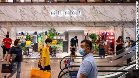 Os compradores passam por uma loja Gucci em Hong Kong. 