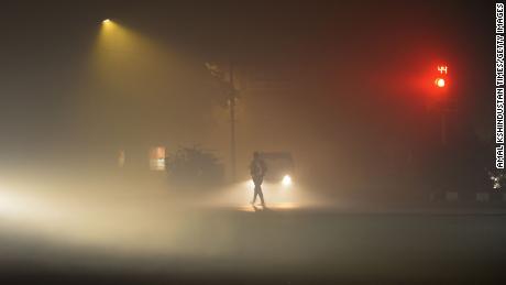 Os veículos circulam com baixa visibilidade devido a uma espessa camada de poluição atmosférica, na noite de Diwali em 4 de novembro em Nova Delhi, Índia.