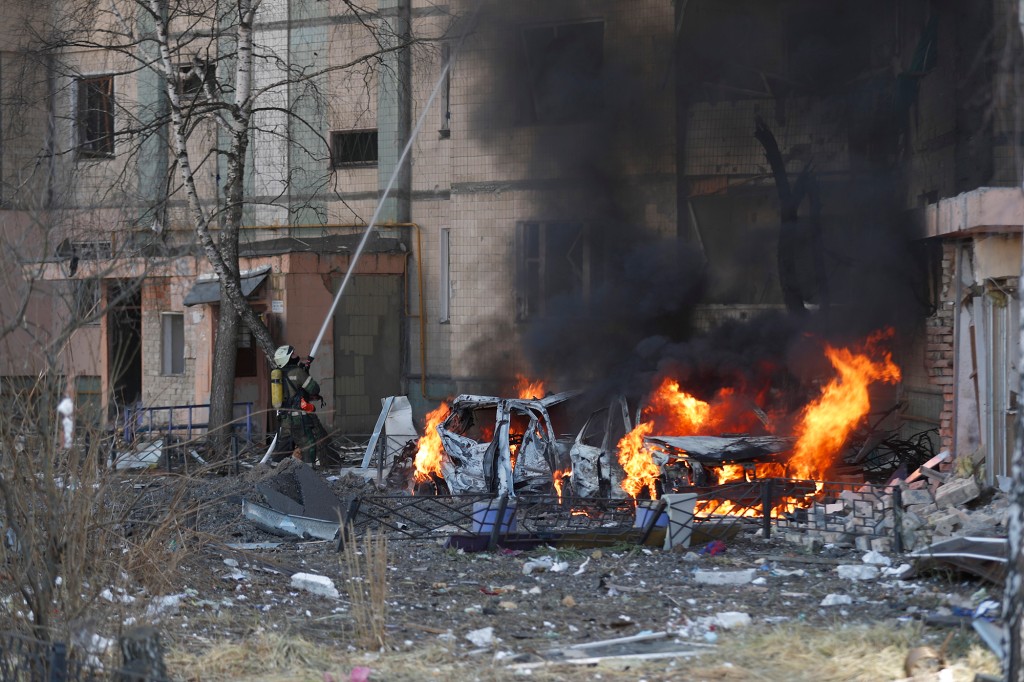 Bombeiros ucranianos e equipes de segurança no local de um ataque com mísseis russos em um prédio em Kiev.