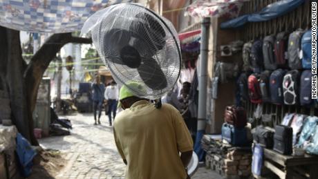 Um homem segura um ventilador durante uma onda de calor em Calcutá, na Índia.