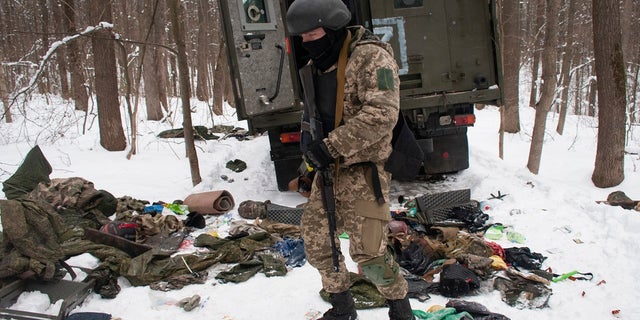 Um voluntário das Forças de Defesa Regionais da Ucrânia inspeciona um veículo militar destruído nos arredores de Kharkiv, a segunda maior cidade da Ucrânia, na segunda-feira, 7 de março de 2022.