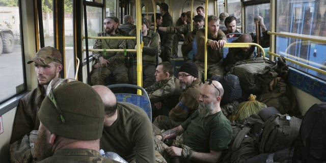 Soldados ucranianos sentam-se em um ônibus após serem evacuados da siderúrgica Azovstal sitiada em Mariupol na terça-feira, 17 de maio. 