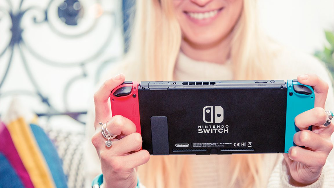 Foto de uma jovem jogando um console Nintendo Switch