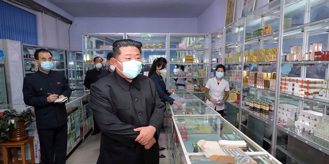 Nesta foto fornecida pelo governo norte-coreano, o líder norte-coreano Kim Jong Un, ao centro, visita uma farmácia em Pyongyang, Coreia do Norte, em 15 de maio de 2022.