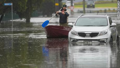 Um homem rema seu barco em uma rua inundada em Windsor, nos arredores de Sydney, Austrália, em 5 de julho de 2022.